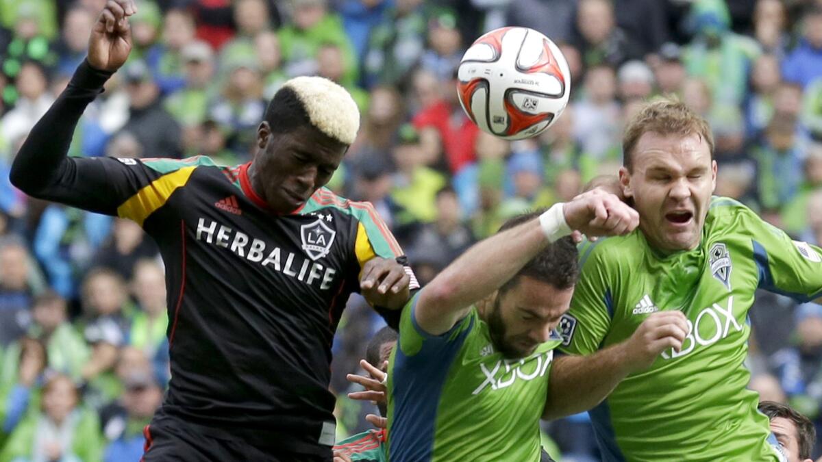 Galaxy forward Gyasi Zardes battles for a header against Sounders defenders Zach Scott, center, and Chad Marshall during a game last season.