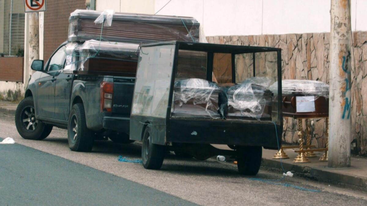 Wrapped coffins sit in the back of a pickup truck outside a hospital in Guayaquil, Ecuador, on April 1, 2020, seen in an image taken from video.