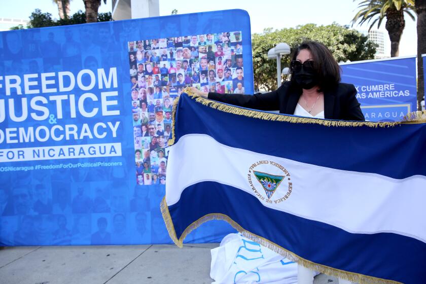 Nicaraguan activist Fidelina Alvarez of Fontana holds a Nicaraguan flag upside down as civil disobedience and an "SOS to the world," at while protesting the IX Summit of the Americas, at the Los Angeles Convention Center on Monday, June 6, 2022.