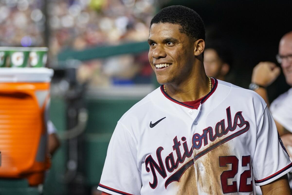 FILE - Washington Nationals' Juan Soto smiles in the dugout after a solo home run during a baseball game against the New York Mets at Nationals Park, Monday, Aug. 1, 2022, in Washington. the Nationals on Tuesday, Aug. 2, 2022, in one of baseball's biggest deals at the trade deadline, vaulting their postseason chances by adding a World Series champion who is one of baseball’s best hitters in his early 20s. A person with direct knowledge of the move told The Associated Press the Padres and Nationals have agreed to a multiplayer deal contingent on San Diego first baseman Eric Hosmer waiving his no-trade provision. The person spoke to the AP on condition of anonymity because negotiations were ongoing. (AP Photo/Alex Brandon, File)