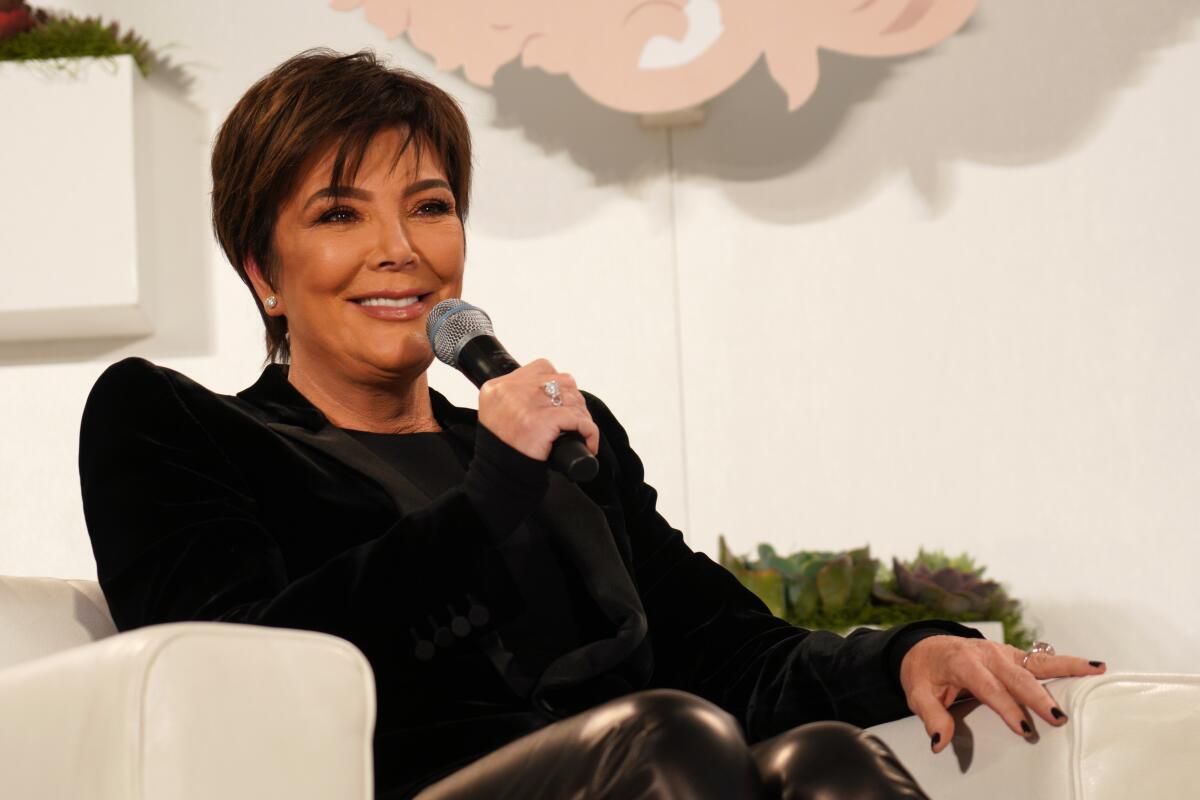 Kris Jenner in a chair talking into a microphone