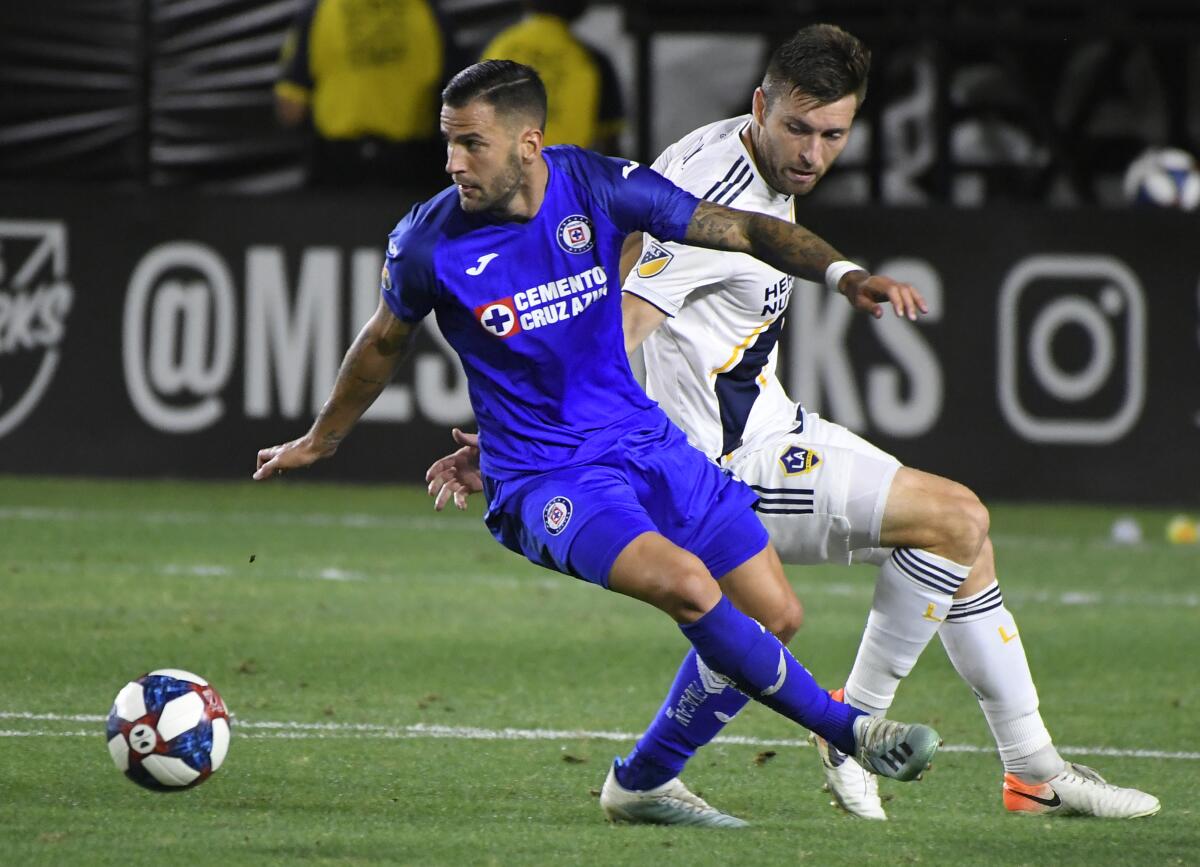 Cruz Azul's Edgar Mendez, left, and Galaxy's Dave Romney battle for the ball in the second half at Dignity Health Sports Park on Tuesday in Carson.