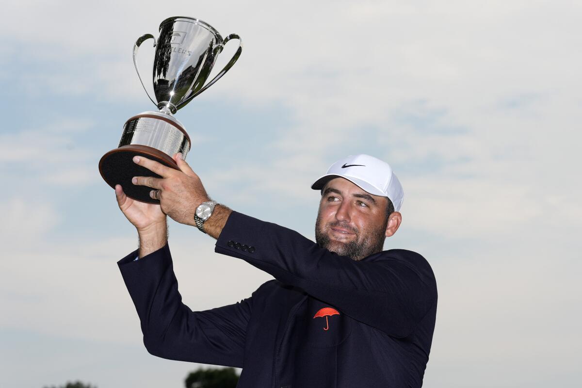 Scottie Scheffler holds aloft the winner's trophy on Sunday at the Travelers Championship, his sixth PGA victory of the year.