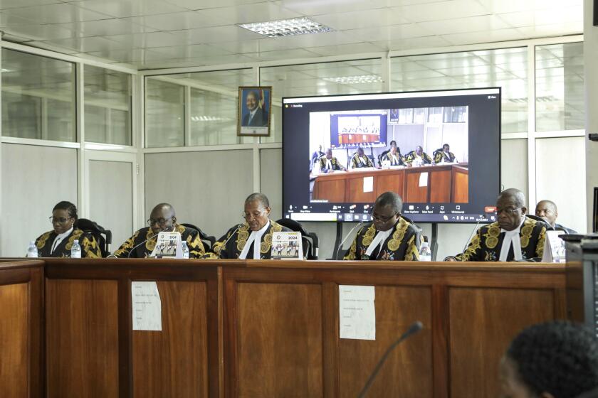The panel of five judges of the Constitutional Court led by the country's chief justice, Richard Buteera, in Kampala, Uganda, Wednesday, April 3, 2024, gives its seal of approval on the anti-homosexuality law, declaring that the Anti Homosexuality Act of 2023 complies with the Constitution of Uganda.(AP Photo/Hajarah Nalwadda )