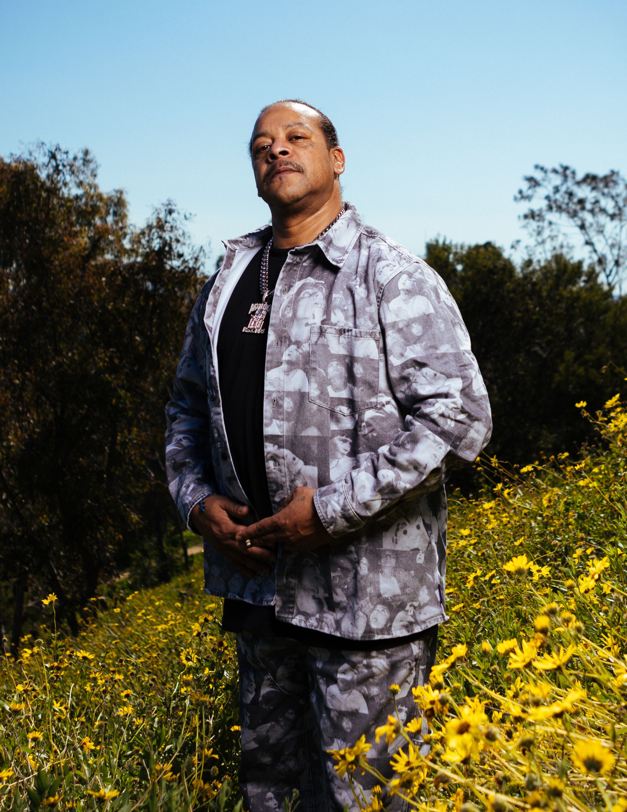 Suga Free poses in a field of flowers.