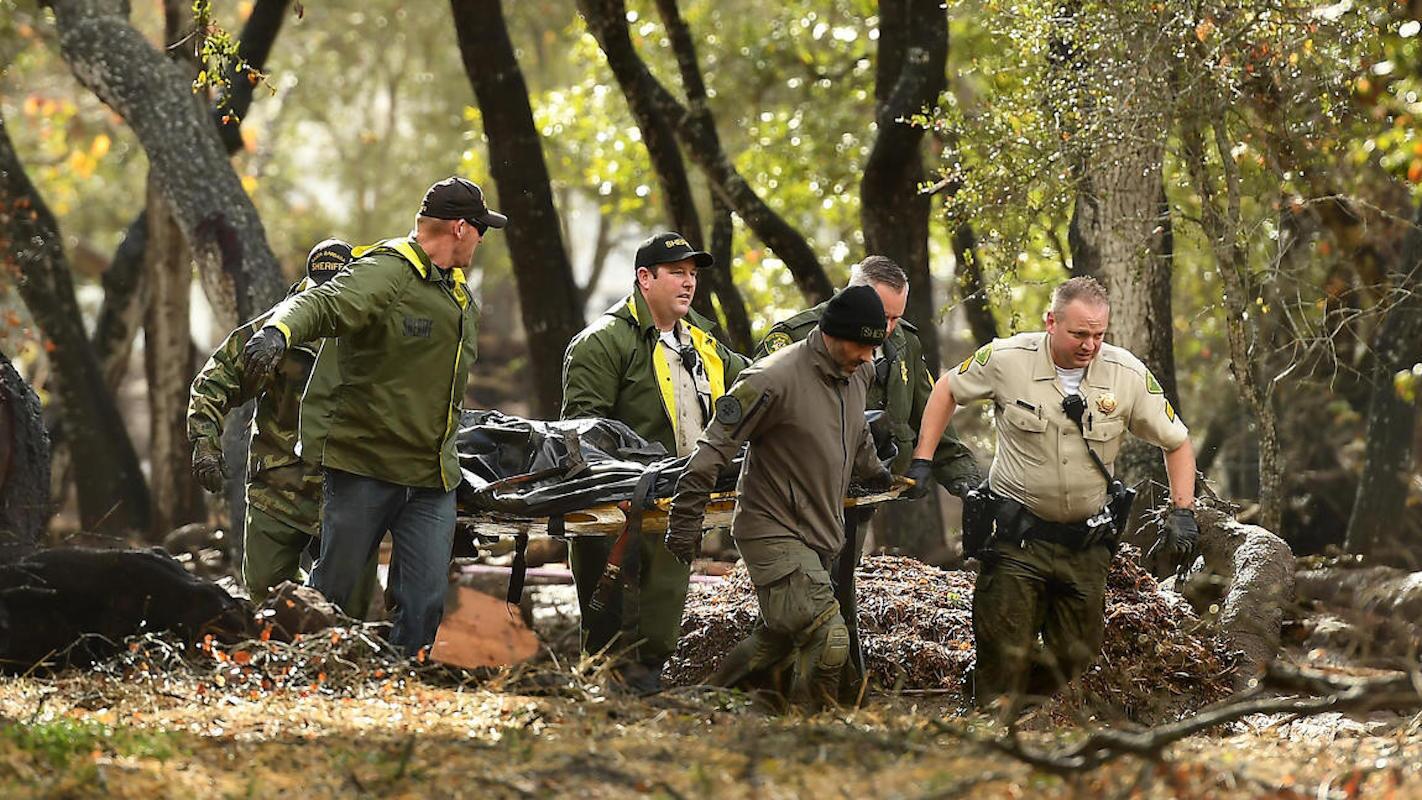 Agentes del Sheriff cargan un cuerpo entre las puedras y el lodo, cerca de Hot Springs Road, en Montecito, después de que una gran tormenta azotó un área que días antes se había incendiado.