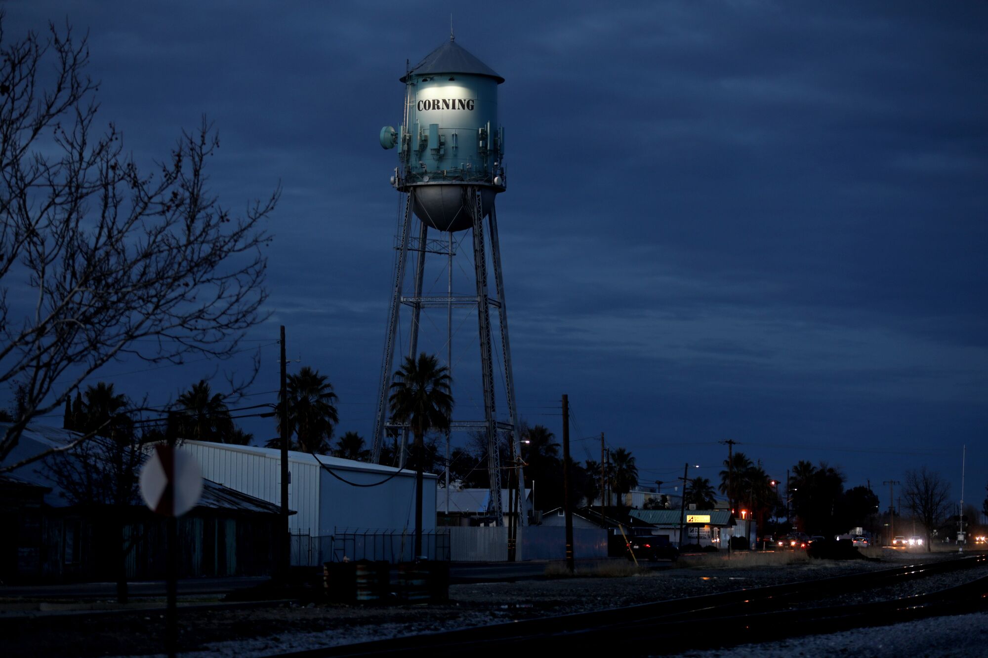 A water tower with the word Corning on it is seen at night