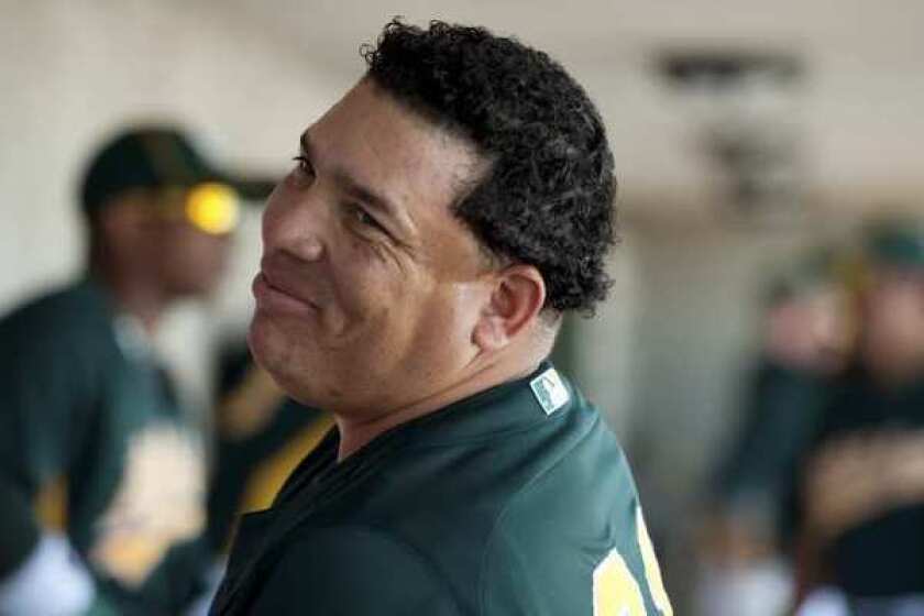 Bartolo Colon smiles in the dugout before his start in a spring training game in Phoenix.