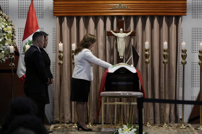 Kenji Fujimori y su hermana Keiko observan cómo la presidenta peruana Dina Boluarte presenta sus respetos al fallecido expresidente Alberto Fujimori durante su velorio en Lima, Perú, el jueves 12 de septiembre de 2024. (AP Foto/Guadalupe Pardo)