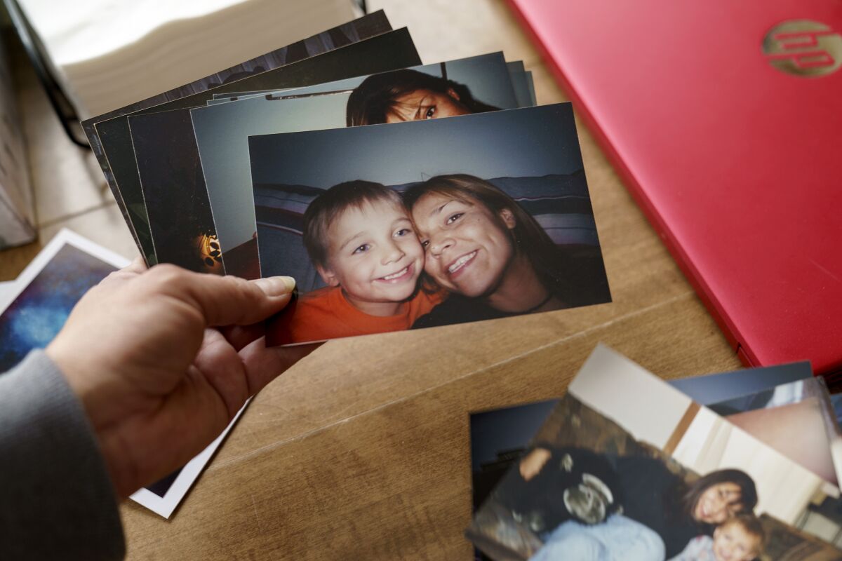 Rachel Taylor looks through old photos of her with her son as a young boy.