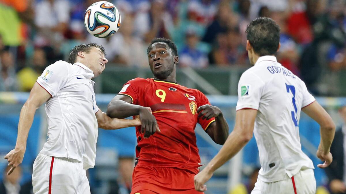 U.S. teammates Matt Besler, left, and Omar Gonzalez, right, battle for the ball with Belgium's Romelu Lukaku during the USA's 2-1 loss at the World Cup on Tuesday.