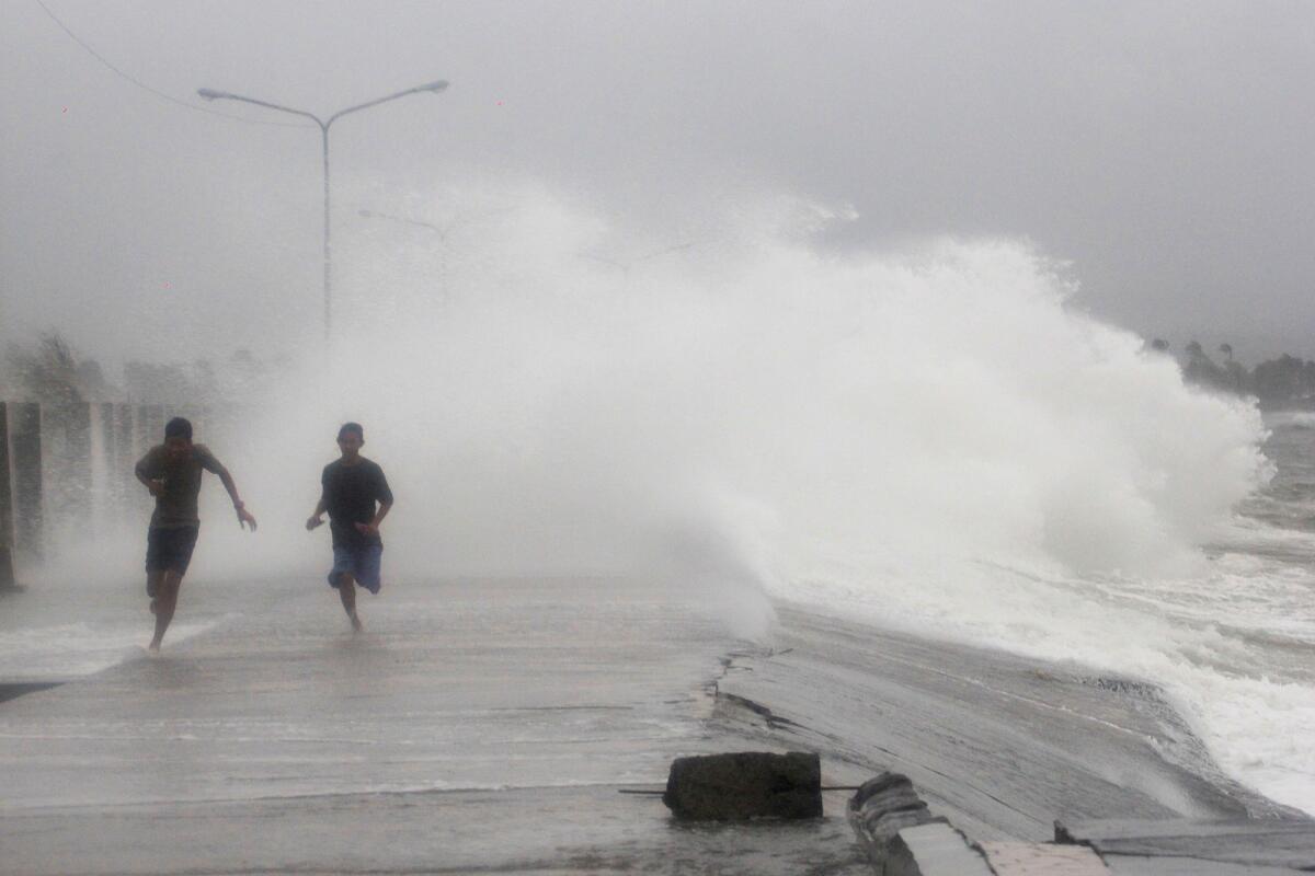 Filipinos flee strong waves churned up by Typhoon Hagupit at a coastal village in Legazpi, in Albay province, on Dec. 7.