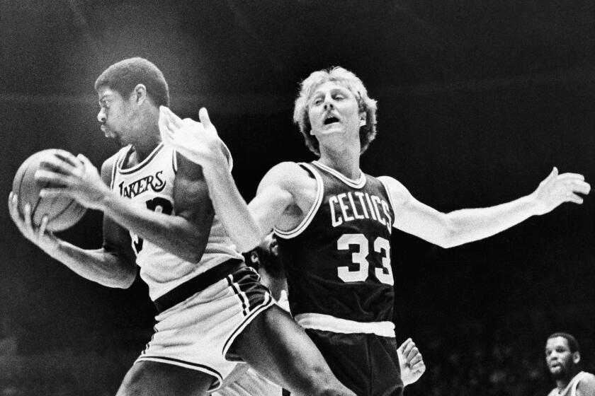 Earvin "Magic" Johnson (32) and Larry Bird (33) in their first professional game against each other.