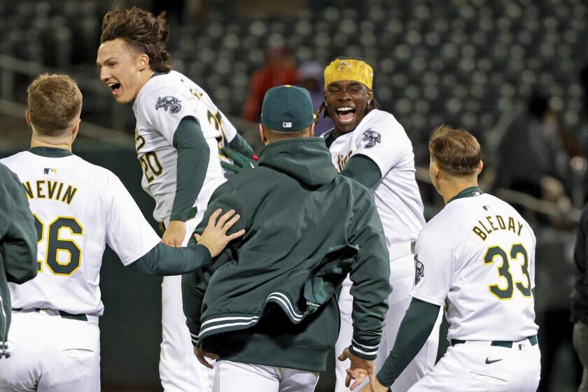 Oakland Athletics' Lawrence Butler, second from right, celebrates his walk-off single in the 10th inning of a baseball game against the Washington Nationals at the Coliseum in Oakland, Calif., Friday, April 12, 2024. The A's won 2-1 in the 10th. (Santiago Mejia/San Francisco Chronicle via AP)