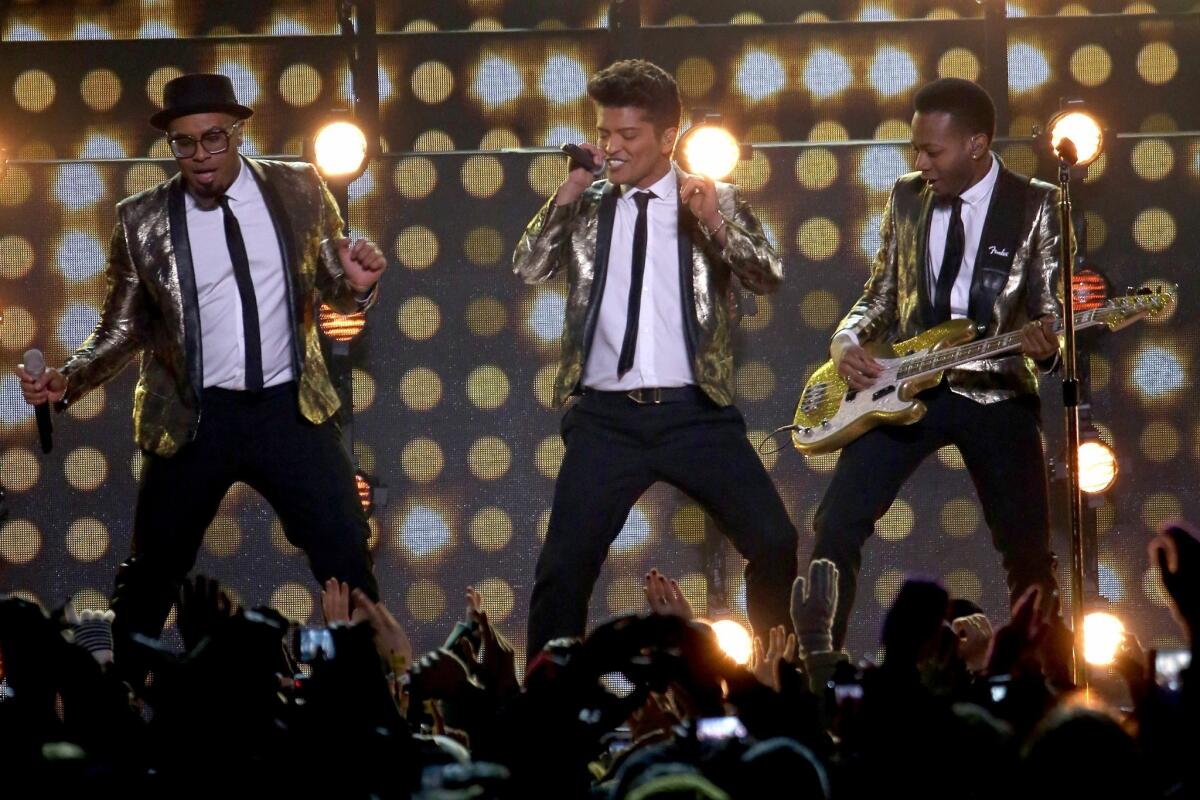 Bruno Mars, center, performs with his band during the Super Bowl XLVIII halftime show.