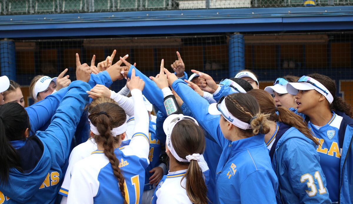 UCLA softball players huddle in March.
