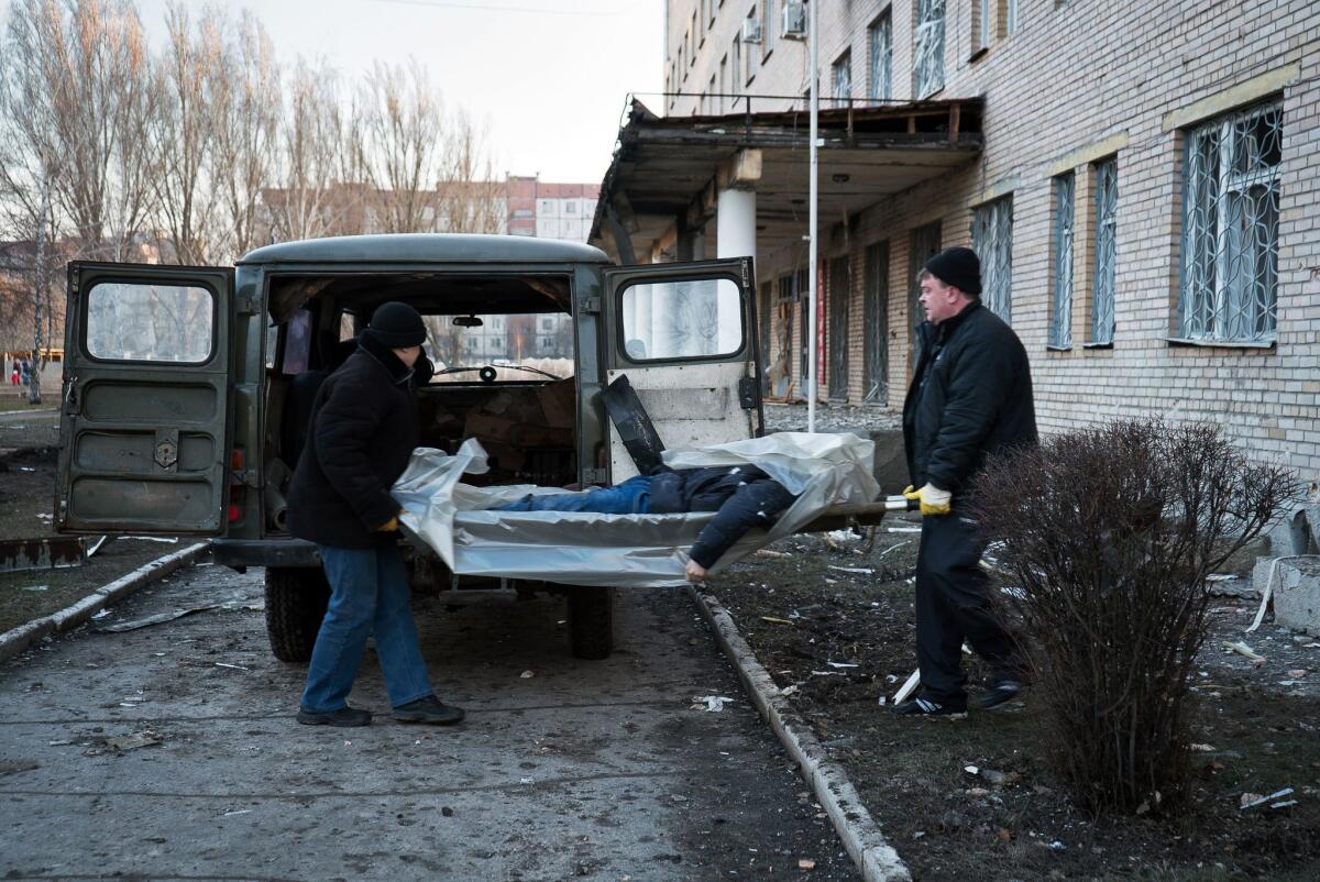 The body of a man killed by shelling that hit a hospital in Donetsk is removed on Wednesday.
