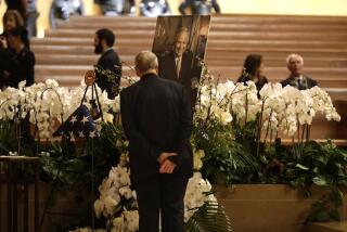 LOS ANGELES, CA - APRIL 28, 2023 - Msgr. Lloyd Torgerson, pastor at St. Monica Catholic Church, looks over a portrait of Mayor Richard Riordan before the Memorial Mass for the former Los Angeles mayor at Our Lady of the Angels in downtown Los Angeles on April 28, 2023. Msgr. Lloyd Torgerson, pastor at St. Monica Catholic Church, which was Riordan's parish. (Genaro Molina / Los Angeles Times)