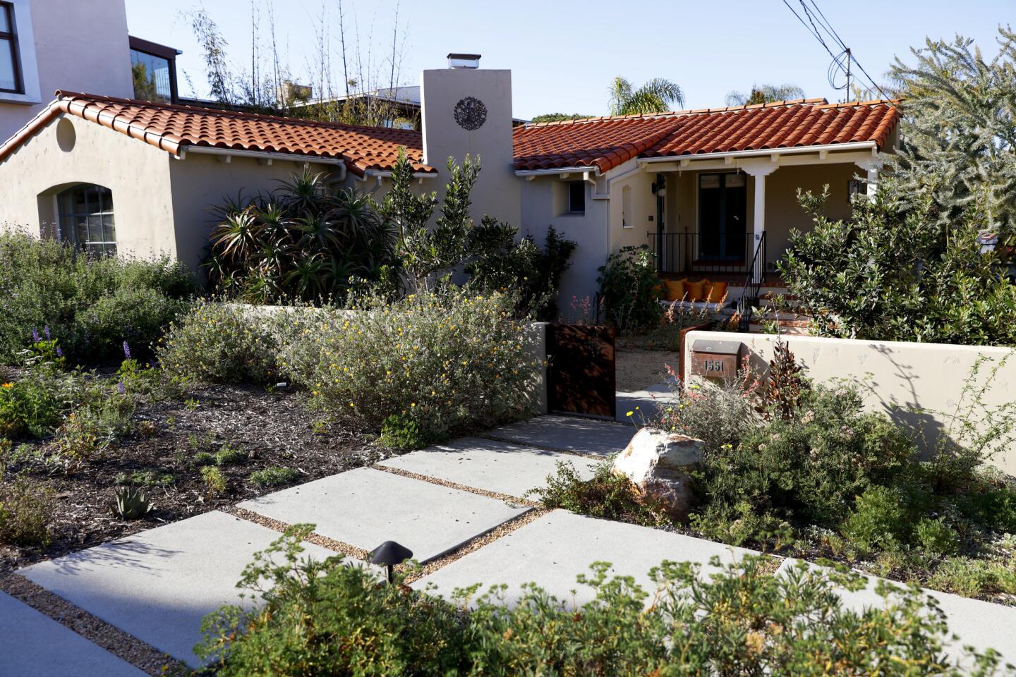The Olsens' front yard originally featured a semi-circular driveway that took up much of the yard. Today, it features a selection of California native and some nonnative, drought-tolerant plants. Oakley Gardens added California gravel in between the pavers shown here that will allow water to percolate back in to the soil.