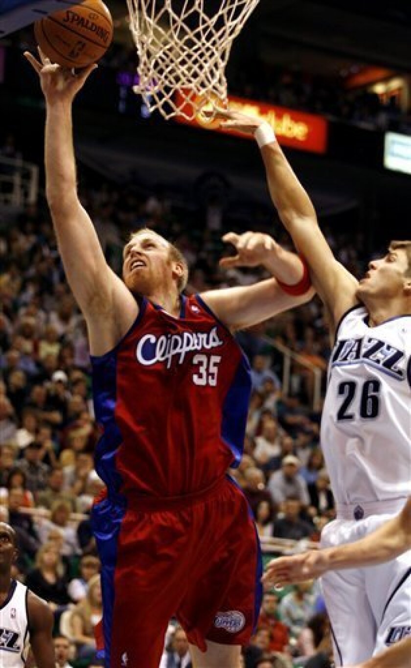 Los Angeles Clippers center Chris Kaman, left, gets to the basket for a shot past Utah Jazz forward Kyle Korver, right, during the first half of their NBA basketball game Saturday, Nov. 1, 2008 in Salt Lake City. (AP Photo/Steve C. Wilson)