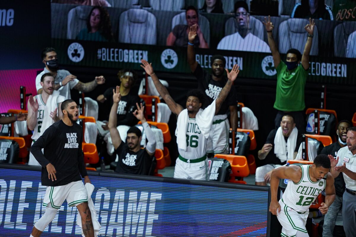 The Boston Celtics bench celebrates during the second half of an NBA basketball game against the Brooklyn Nets Wednesday, Aug. 5, 2020 in Lake Buena Vista, Fla. (AP Photo/Ashley Landis)