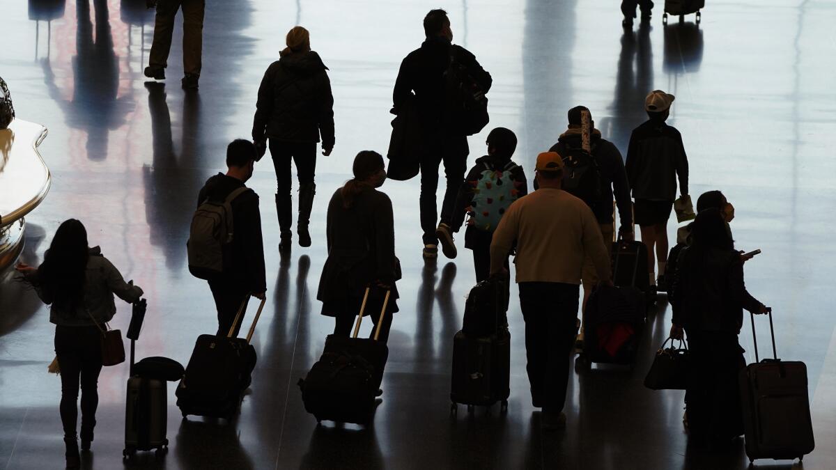 Travelers walk through the Salt Lake City International Airport in Salt Lake City a day before Thanksgiving.