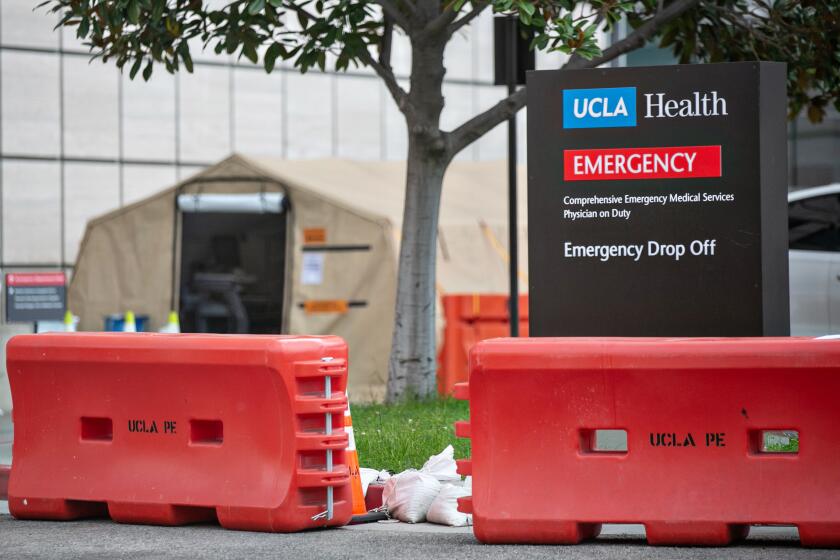 LOS ANGELES, CA - JANUARY 10: People enter UCLA Medical Center in Westwood, were there are tents outside the ER to triage and treat the overflow of patients on Sunday, Jan. 10, 2021 in Los Angeles, CA. (Jason Armond / Los Angeles Times)