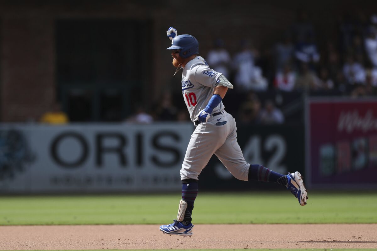 Justin Turner celebrates as he circles the bases after hitting a grand slam against the Padres on Sunday.