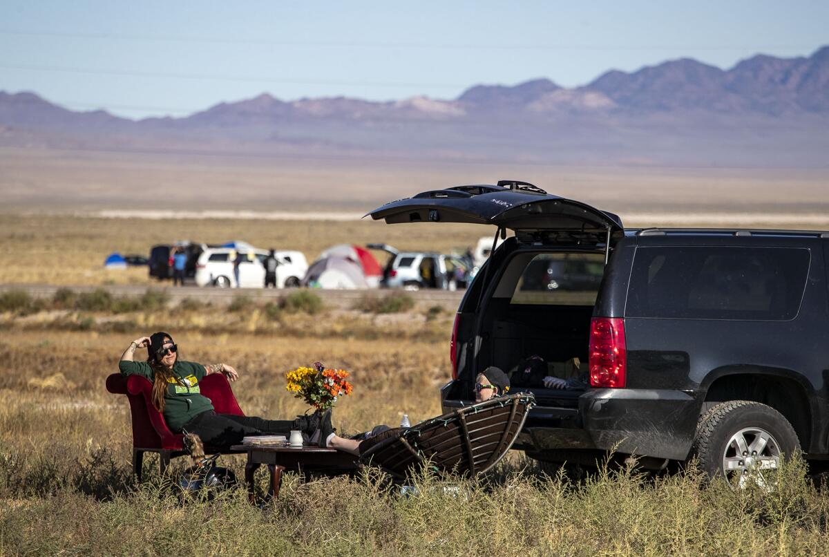Lacking camping gear, Las Vegans Cassie Cazessus, left, and Cassandra Steed, right, brought their living room furniture to relax on at the Area 51 adjacent town of Rachel, NV.