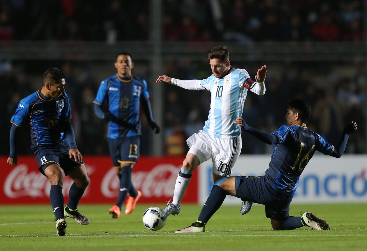 El delantero argentino Lionel Messi pasa con el balón entre jugadores de la selección de Honduras en un partido amistoso en San Juan, Argentina, el viernes 27 de mayo de 2016. Messi cumplía el lunes 30 de mayo un "reposo deportivo" por un golpe que lo sacó de la cancha en el amistoso del viernes, lo que agiganta las dudas por su presencia con Argentina ante Chile dentro de una semana por la Copa América Centenario. (AP Foto/Nicolás Aguilera) ** Usable by HOY, ELSENT and SD Only **