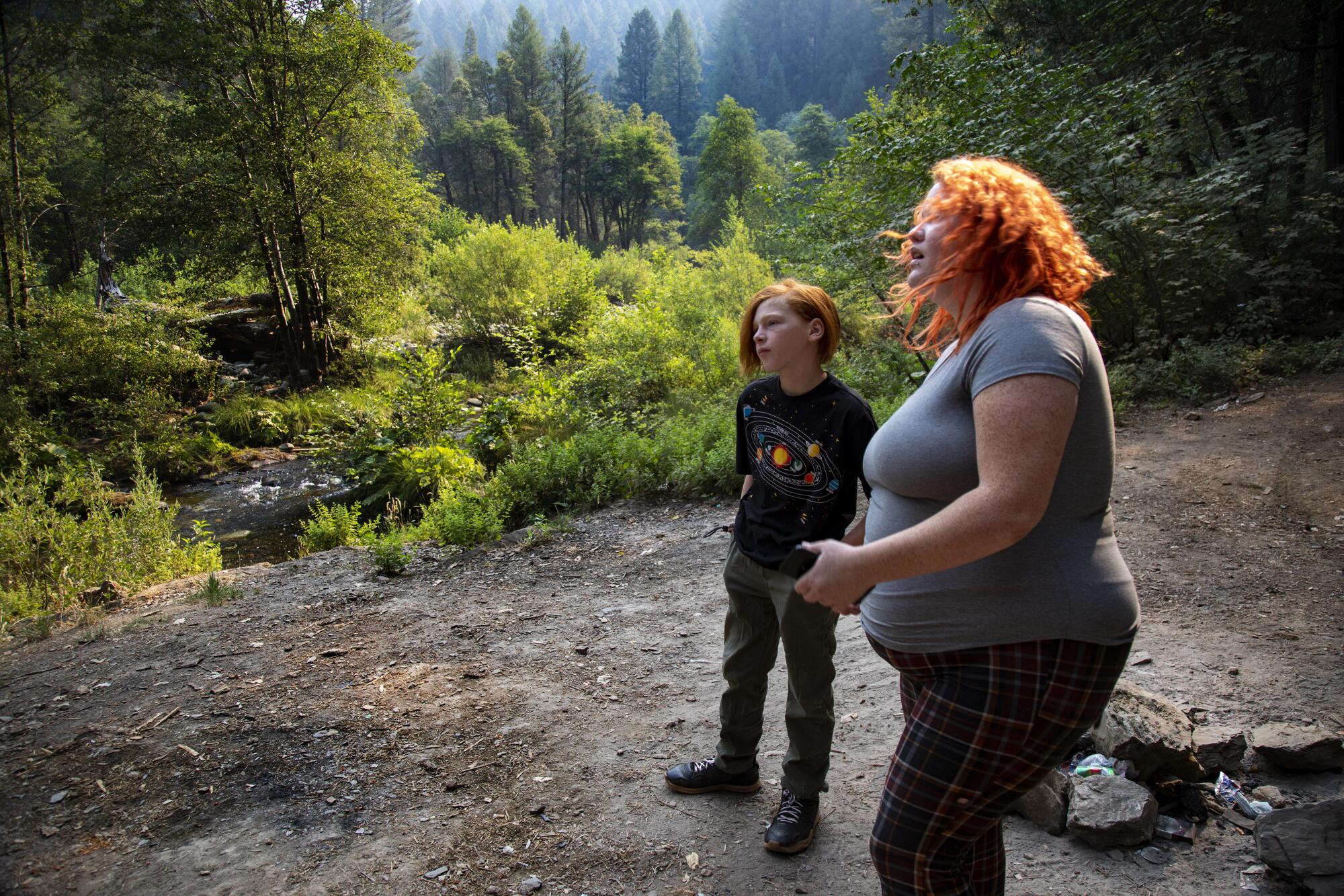 Kayla Wilson and son JJ stand at a wilderness campsite.