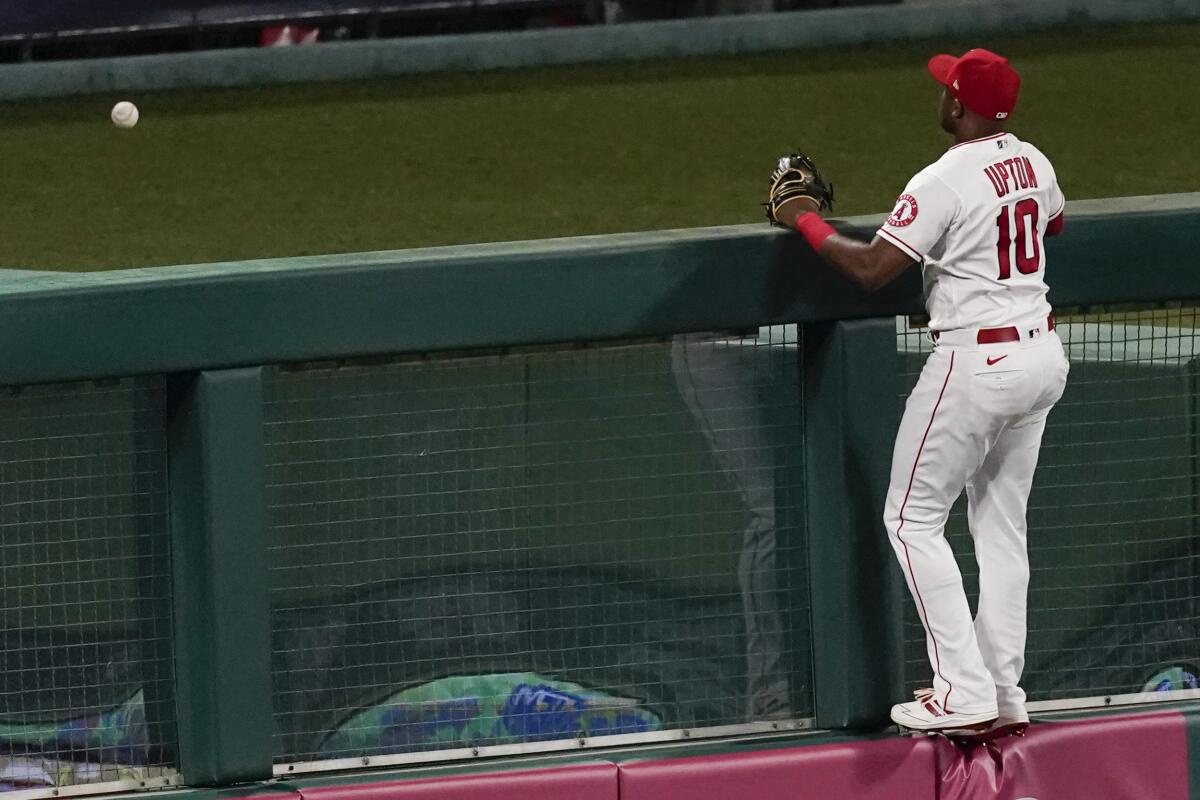 Angels left fielder Justin Upton watches as a home run hit by Oakland's Aramis Garcia.