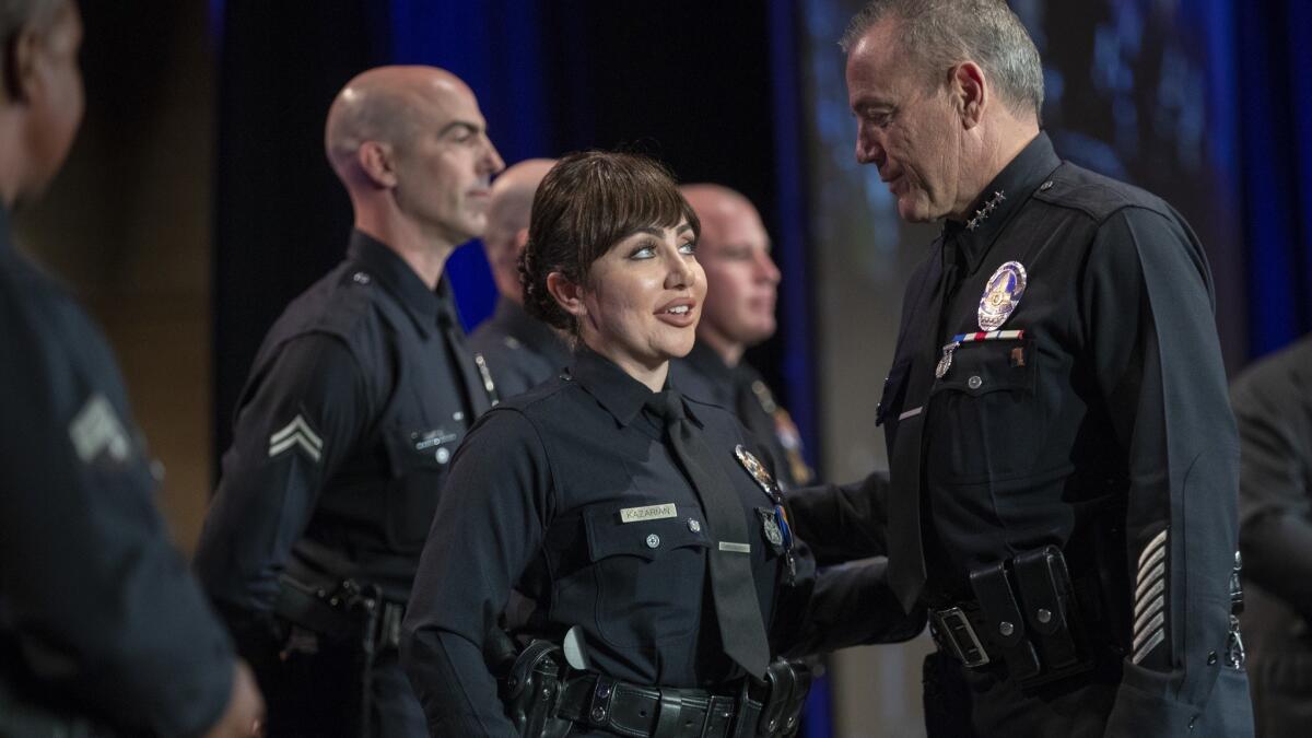LAPD Michel Moore congratulates Suzanna Kazarian while awarding her the Preservation of Life medal, recognizing officers who avoid the use of deadly force.