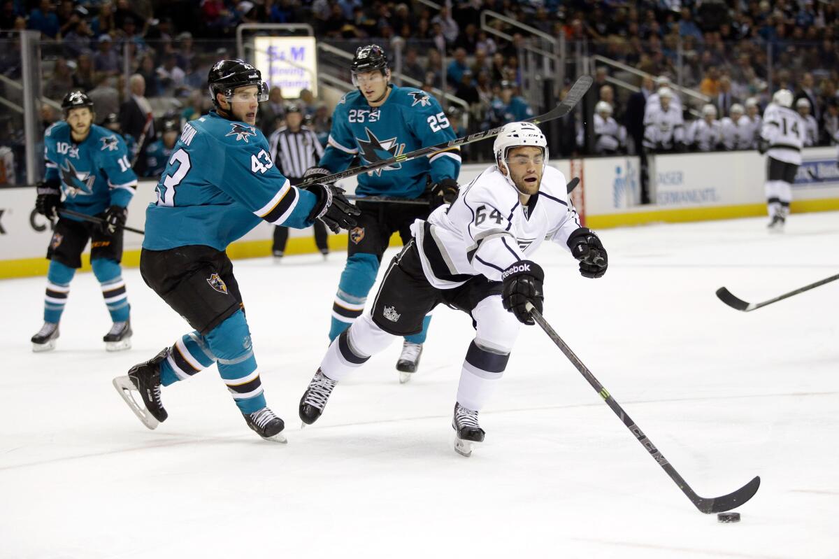 Kings' Andy Andreoff reaches for the puck in front of San Jose's Taylor Fedun during a preseason game on Sept. 30.