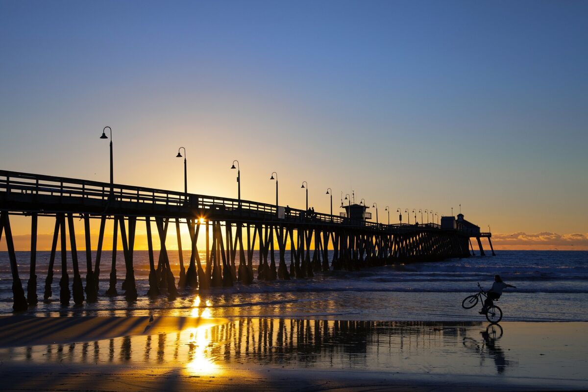 A bicycle rider enjoying the low tide in Imperial Beach cruises his bike near Imperial Beach Pier.