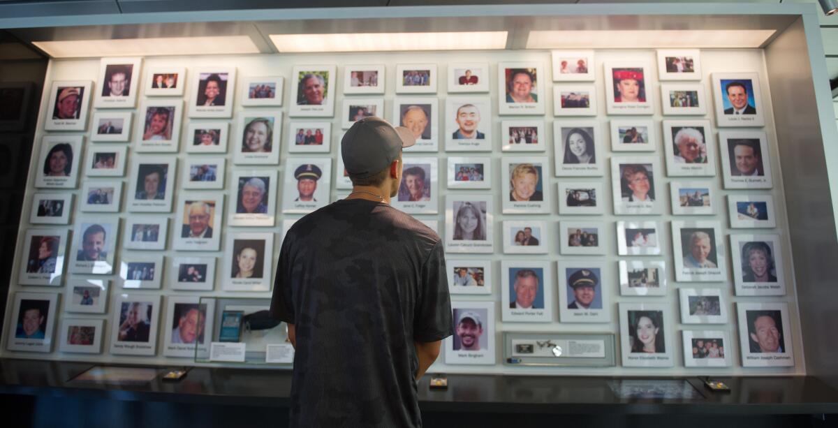 A visitor at the Flight 93 National Memorial in Shanksville, Pa., looks through the portraits of the passengers and crew who died when the hijacked plane crashed on Sept. 11, 2001.