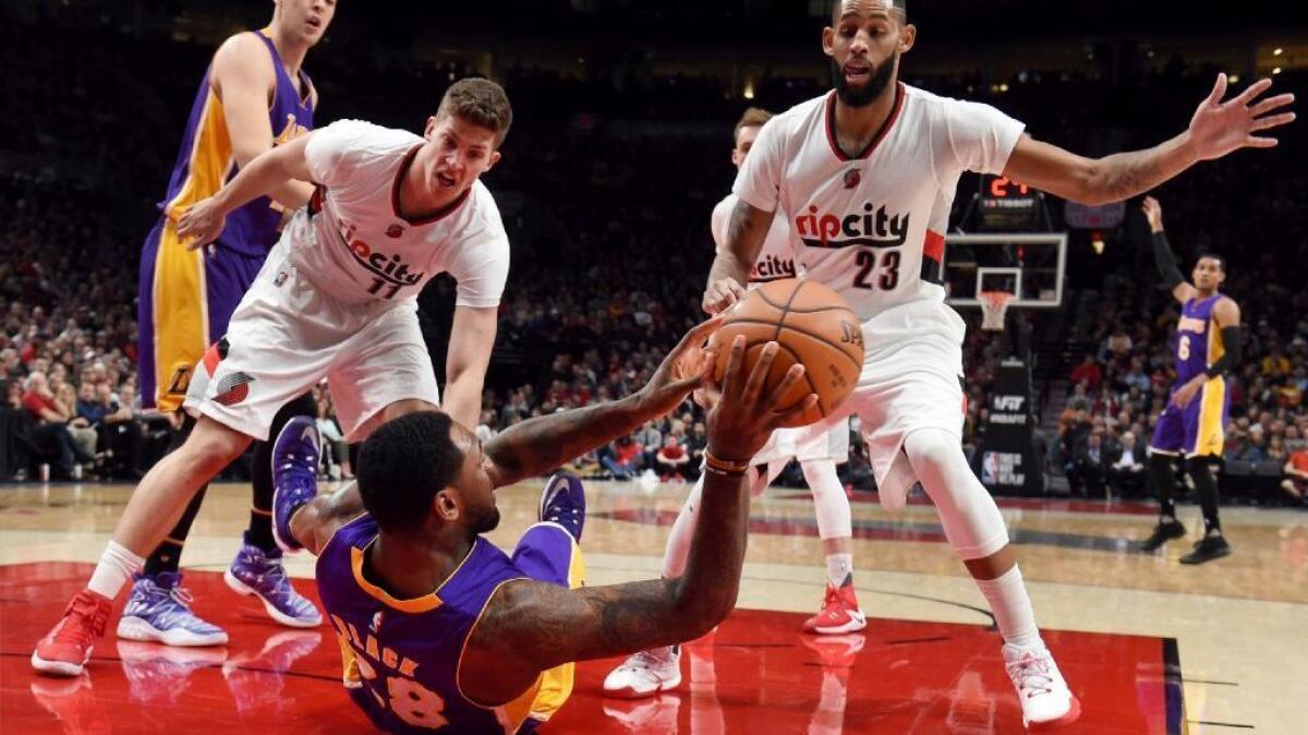 Lakers center Tarik Black hits the deck while chasing a loose ball during a game against the Trail Blazers in Portland, Ore. on Jan. 25.