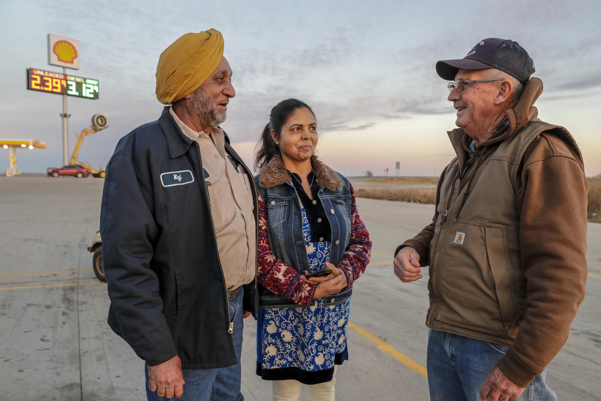 Truck Stop 40 owners Raj Chhoker, left, and his wife, Harpreet Chhoker, chat with their neighbor Kenny Drake.