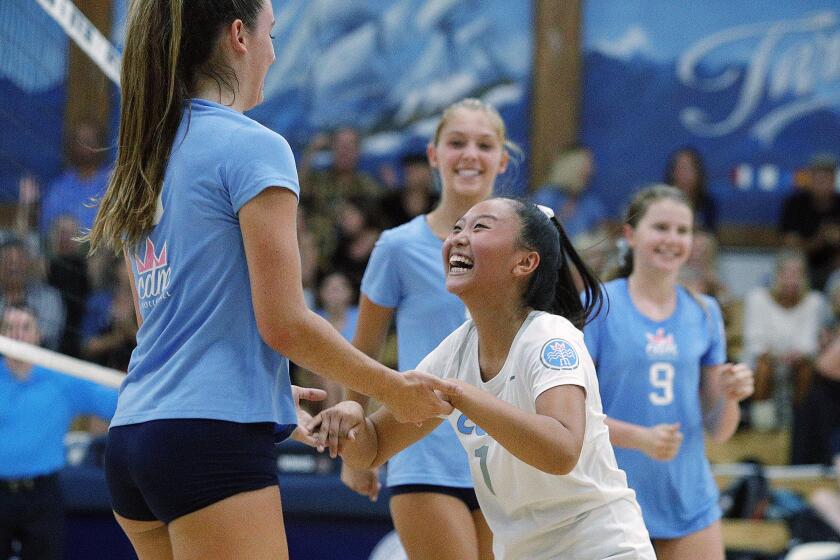 Corona del Mar's Molly Joyce gets a big congratulations from teammate Michelle Won after hitting a cross court hit for a point against Newport Harbor in a non-league girls' volleyball match at Newport Harbor High School on Thursday, September 12, 2019.