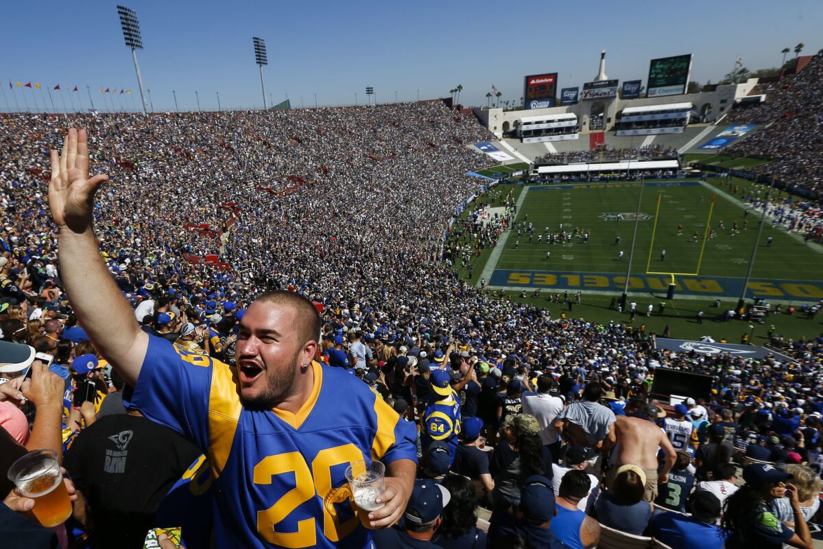 Fans cheer for the Los Angeles Rams during a 9-3 victory over the Seattle Seahawks at the Coliseum on Sept. 18, 2016.