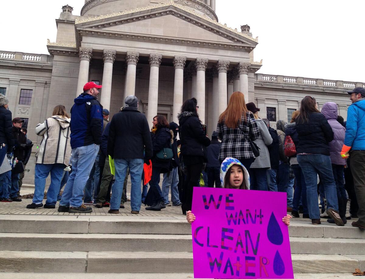 Emma Del Torto of Charleston, W.Va., holds a sign during a demonstration at the state Capitol on Jan. 18. More than 100 people gathered to question the safety of their tap water.