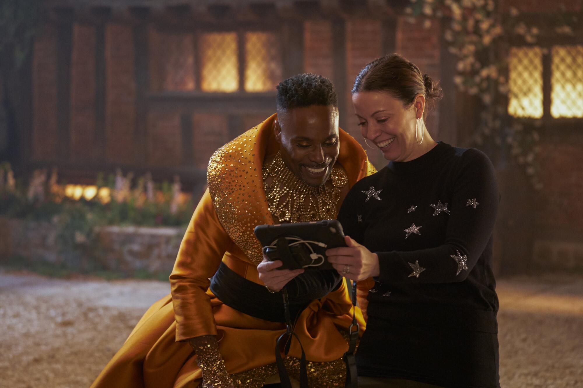 Billy Porter and Kay Cannon look at a tablet on the set of "Cinderella."
