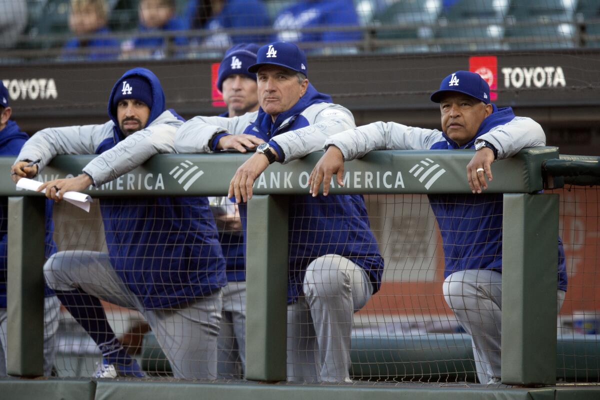 Dodgers bench coach Bob Geren, center, and manager Dave Roberts, right, look on during a game against the Giants on May 21.