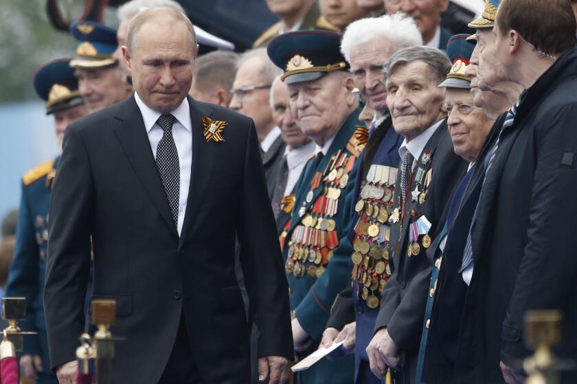 FILE - In this Thursday, May 9, 2019 file photo, Russian President Vladimir Putin walks to attend a military parade marking 74 years since the victory in WWII in Red Square in Moscow, Russia. Spring is not turning out the way Russian President Vladimir Putin might have planned it. A nationwide vote on April 22, 2020 was supposed to finalize sweeping constitutional reforms that would allow him to stay in power until 2036, if he wished. But after the coronavirus spread in Russia, that plebiscite had to be postponed an action so abrupt that billboards promoting it already had been erected in Moscow and other big cities. (AP Photo/Alexander Zemlianichenko, File)