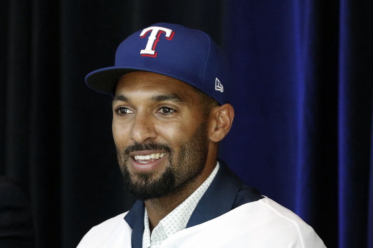FILE - New Texas Rangers infielder Marcus Semien answers questions at a news conference at Globe Life Field, Dec. 1, 2021, in Arlington, Texas. Semien and Corey Seager are finally on the field together and able to talk about what they want to accomplish with the Rangers, who committed a half-billion dollars to the middle infielders just before the Major League Baseball lockout. (AP Photo/Richard W. Rodriguez, File)