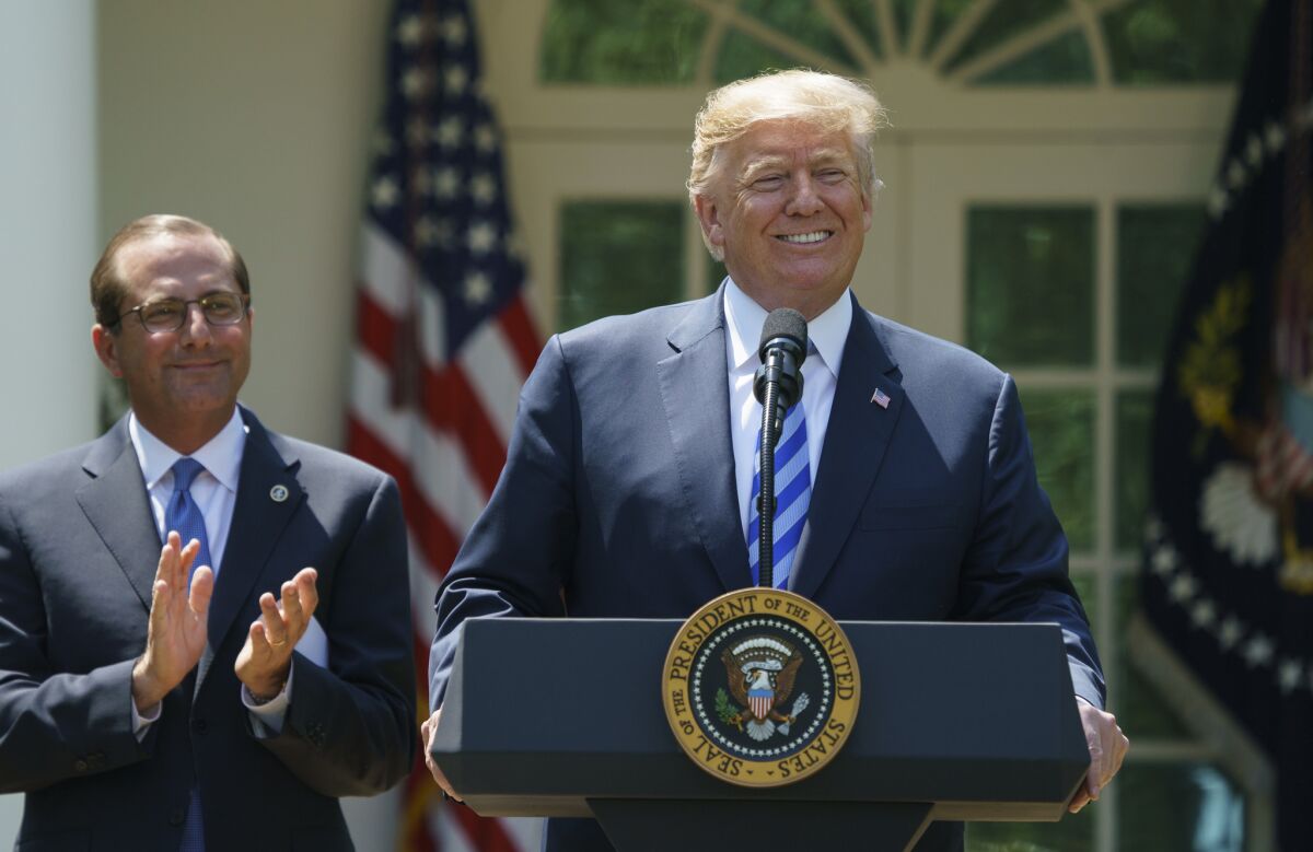 Partners in the attack on your healthcare: President Trump with Health and Human Services Secretary Alex Azar at a White House ceremony in 2018.