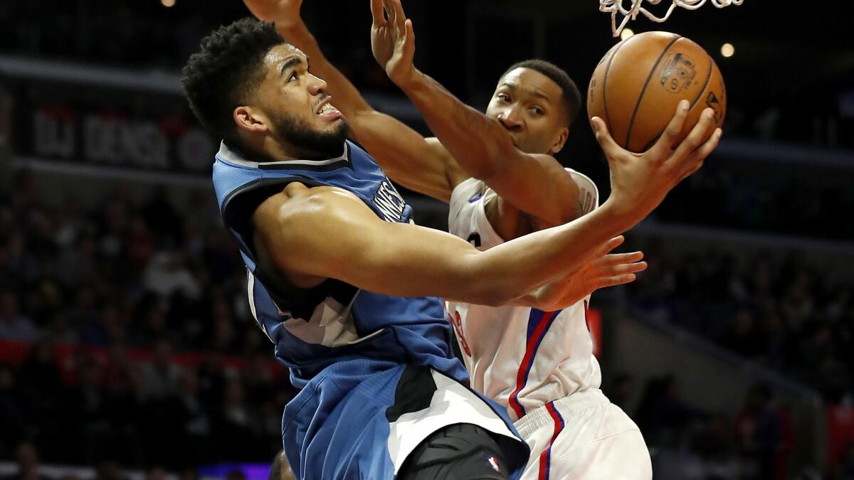 Timberwolves center Karl-Anthony Towns attempts a reverse layup against Clippers forward Wesley Johnson during a Jan. 19 game at Staples Center.