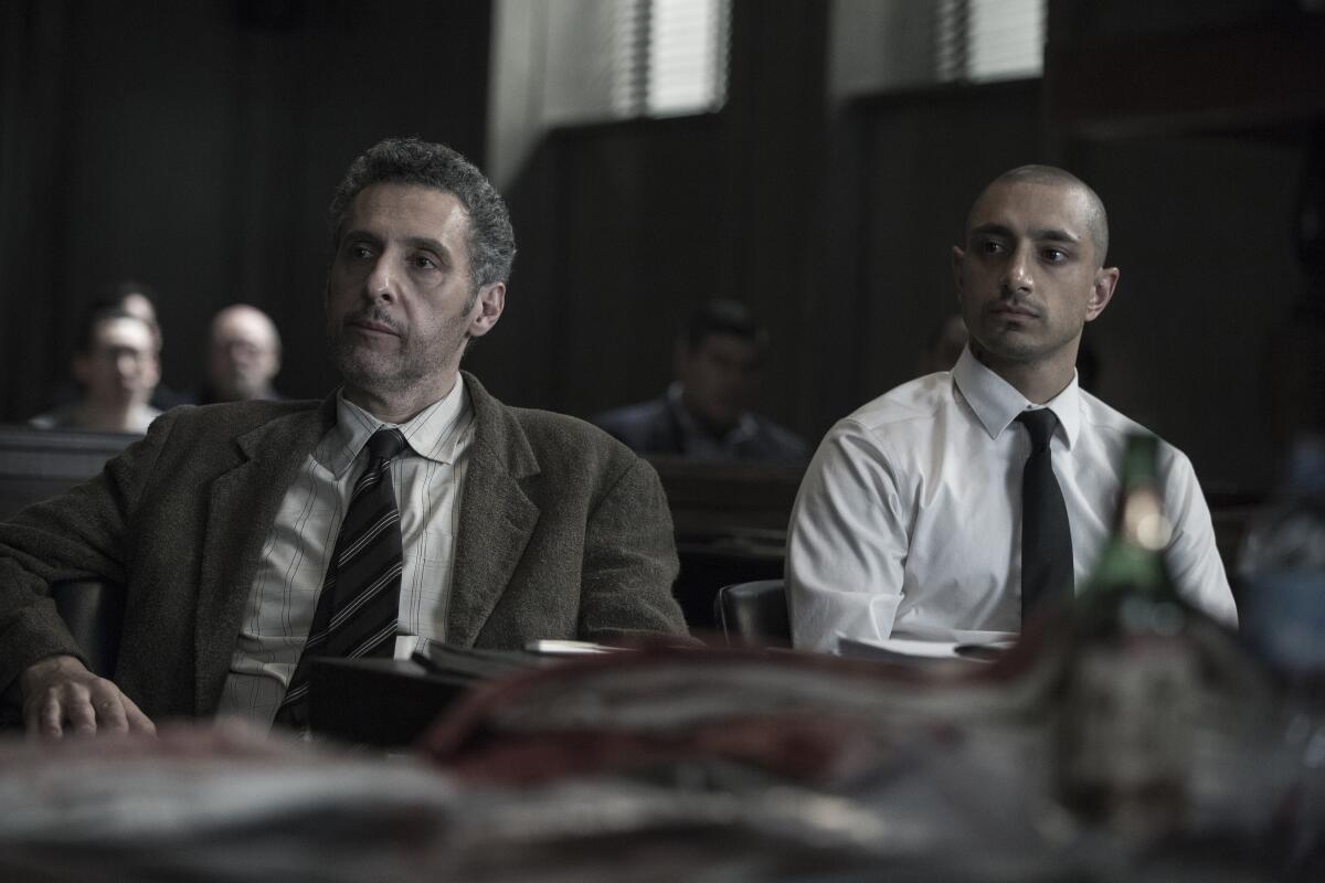 Two men sit at a table in a courtroom.