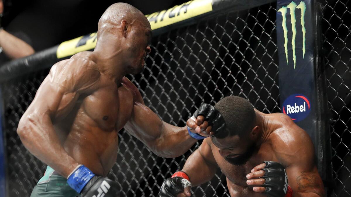 Kamaru Usman, left, hits Tyron Woodley during a welterweight bout at UFC 235 in Las Vegas.