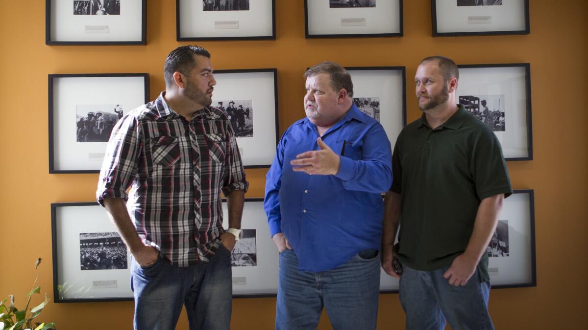 Plaintiffs Peter Guzman, left, Dan McKibben, and Sean Lint are shown in 2014 at ACLU headquarters in Los Angeles, after their class-action lawsuit was announced alleging discrimination against gay, bisexual and transgender inmates at the West Valley Detention Center.
